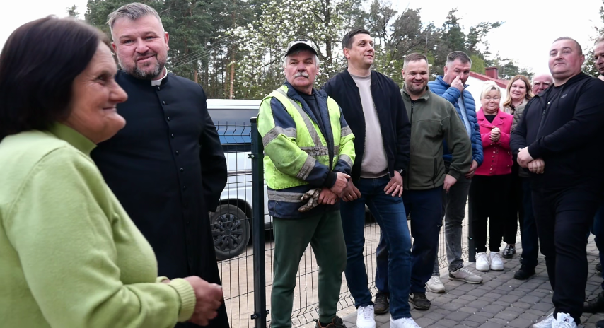 Grupa osób stoi obok siebie 