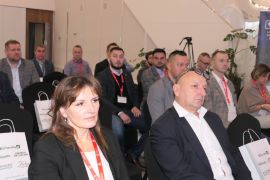 Grupa osób siedząca obok siebie na krzesłach 