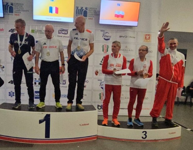 Zawodnicy w dresach stoją na podium 
