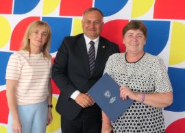 Dwie panie i mężczyzna stoją obok siebie. 