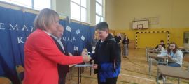 Uczeń odbiera gratulacje za zwycięstwo w konkursie matematycznym