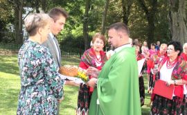 Ksiądz błogosławi dożynkowy chleb