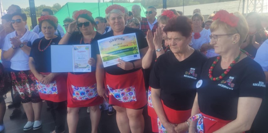 Grupa kobiet w kolorowych wiankach stoi obok siebie