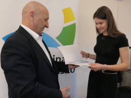 Dziewczyna odbiera nagrodę z rąk mężczyzny 
