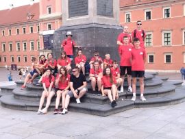 Grupa młodych osób przy jednym z pomników w Warszawie