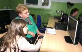 Kobieta i dziewczynka siedzą przed monitorem 