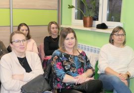 Kobiety siedzą na krzesłach, uczestniczki spotkania