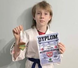 Dziewczynka trzyma w ręku dyplom i medal 