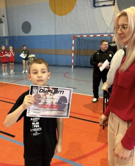 Chłopiec trzyma w ręku dyplom 