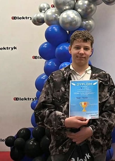 Chłopiec trzyma w ręku dyplom 