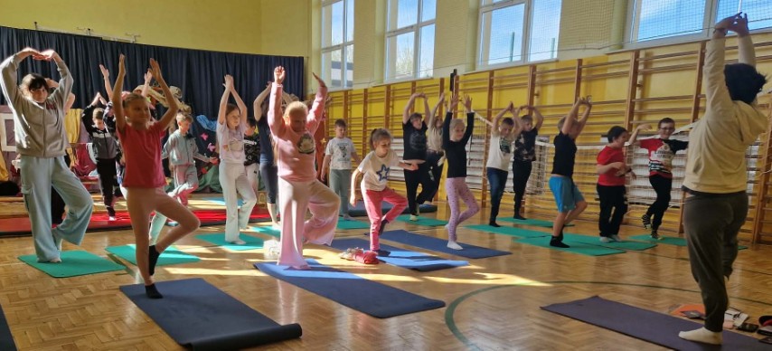 Dzieci podczas zajęć sportowych. Dzieci mają dłonie w górze 