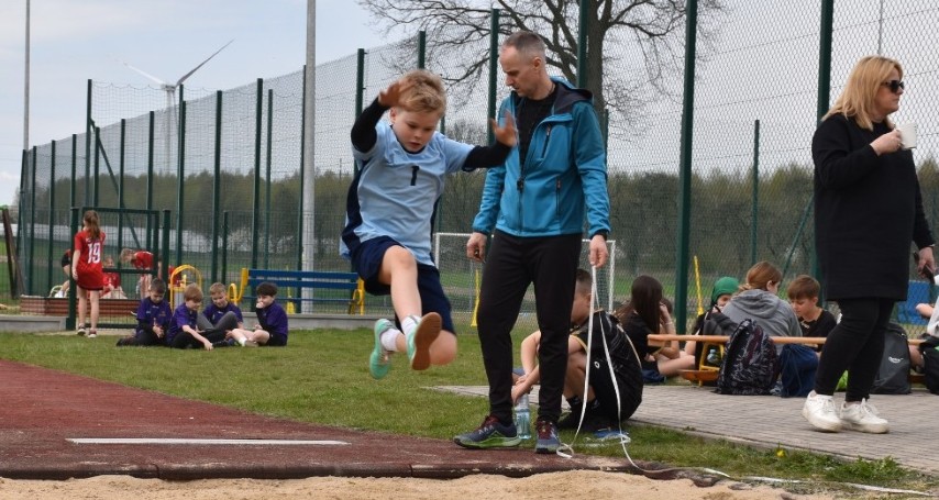 Chłopiec wykonuje skok w dal 