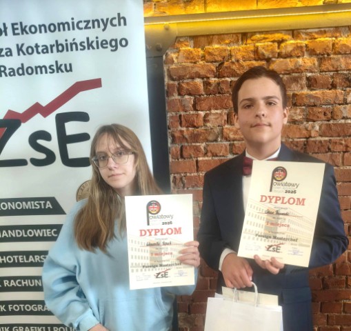 Dziewczyna i chłopak stoją obok siebie. Oboje trzymają w dłoniach dyplomy 