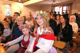 Osoby siedzą w ławkach 