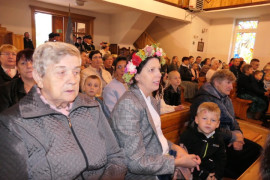 Osoby siedzą w ławkach 