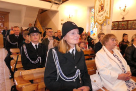 Osoby siedzą w ławkach 