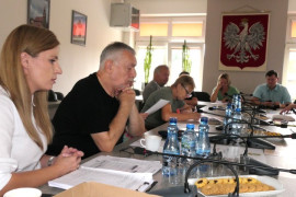 Osoby siedzą przy stole. Uczestnicy spotkania 
