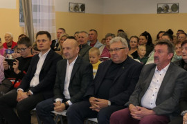 Grupa osób - widzów przedstawienia o tematyce historycznej - siedząca na krzesłach 