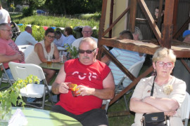 Osoby siedzą przy stoliku. Trwa rodzinny piknik 