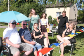 Osoby siedzą na krzesłach. Trwa rodzinny piknik 