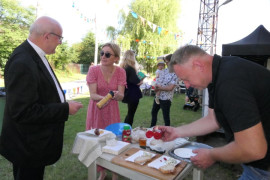 Dwaj mężczyźni i kobieta. Jeden z mężczyzn przygotowuje potrawy 