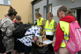Grupa osób podczas podpisywania listy obecności 