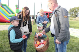 Mężczyzna rozdaje jabłka dzieciom 