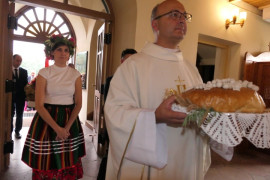 Ksiądz niesie bochen chleba 