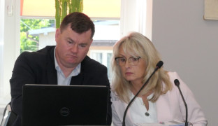 Kobieta i mężczyzna siedzą obok siebie. oboje patrzą w ekran monitora 