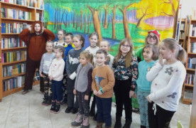Grupa dzieci w towarzystwie osoby przebranej za misia