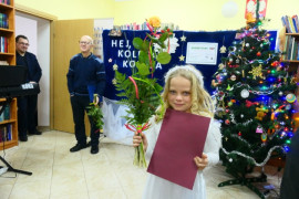 Dziewczynka trzymająca w ręku dyplom i kwiaty