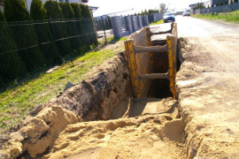 Duży dół w ziemi, w którym znajduje się metalowa konstrukcja