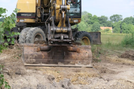 Koparka podczas prac budowlanych przy budowie kanalizacji w miejscowości Strzałków 