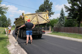 Drogowcy podczas prac drogowych. Pracownik stoi obok samochodu ciężarowego