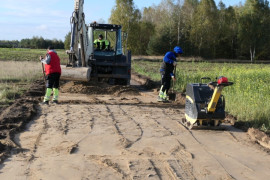 Przebudowa drogi. Widoczni pracownicy i maszyny