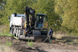 Trwa przebudowa drogi. Widoczne maszyny i pracownicy 