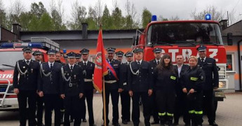 Druhowie OSP Szczepocice w galowych strojach. Za strażakami znajduje się wóz bojowy 