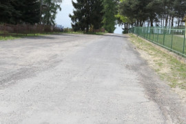 Droga, widoczne zielone ogrodzenie