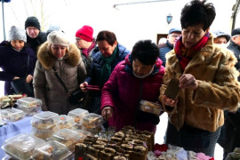 Grupa osób kupująca świąteczne ciasta i ozdoby