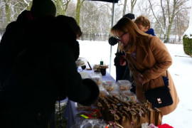 Kobieta kupująca ciasta na jarmarku bożonarodzeniowym  