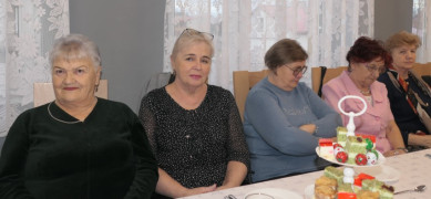 Pięć kobiet siedzi przy stole 