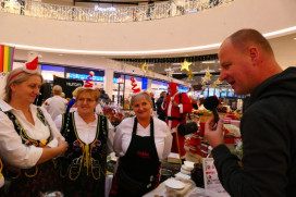 Trzy kobiety i mężczyzna. Mężczyzna trzyma w ręku mikrofon 