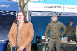 Kobieta stoi przy mikrofonie i przemawia 