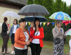 Osoby stoją pod parasolami