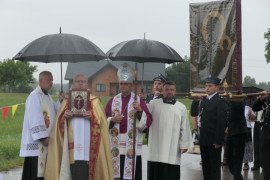 Duchowni idą w procesji Widoczny jest obraz Matki Bożej