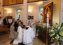 Duchowni i wierni klęczą przed obrazem Matki Bożej