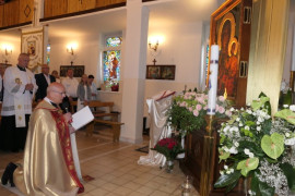 Duchowni klęczy przed obrazem Matki Bożej