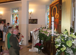Wierni i duchowny klęczą przed obrazem Matki Bożej