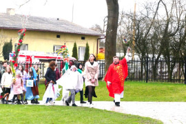 Plac kościelny, widoczni uczestnicy procesji z palmami 