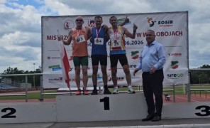 Trzej panowie w sportowych strojach stoją na podium. Pierwszy z prawej Piotr Płoskoński 